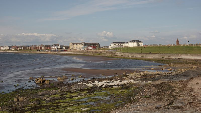 Prestwick seafront on a bright day, with the promenade and grass